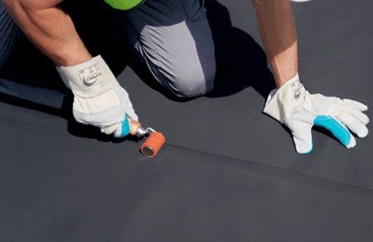 EPDM Kleber wird auf Dachfolie aufgetragen