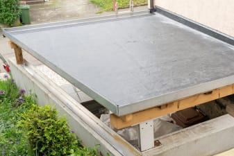 Carport mit flachem Dach, das mit Dachfolie verlegt ist