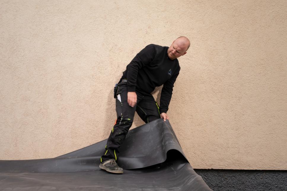 EPDM Folie 1,2 mm beim Ausrollen auf einem Carport für langlebige Dachabdichtung